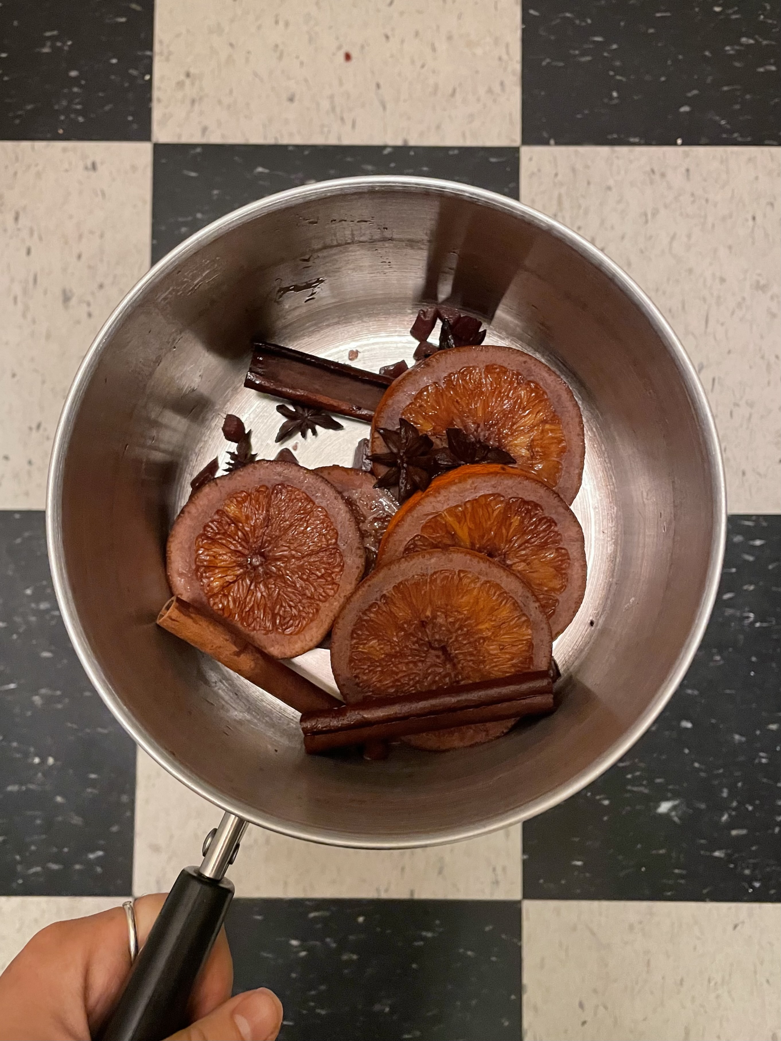 orange slices, star anise, cinnamon sticks, candied ginger, all stained red from wne, in a pot together. the aftermath of mulled wine